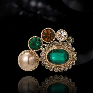Broche vintage avec émeraude et perle sur base dorée et cristaux multicolores