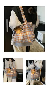 Close-up of vintage orange and blue plaid wool tote bag with a cute brown bear charm