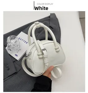Detail view of white retro underarm bag showing textured leather and round handles