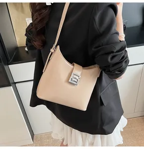 Vista laterale della borsa hobo beige con fibbia in metallo argento sulla modella