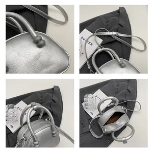 Detail view of silver pleated leather bag with cylindrical handles and metallic texture