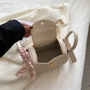 Sac barillet chic en cuir beige avec double poignée et décoration écharpe en soie rose