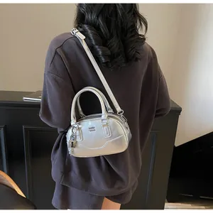 Détail du sac Boston argenté avec lettrage GDH SDN et breloque cadenas brillant