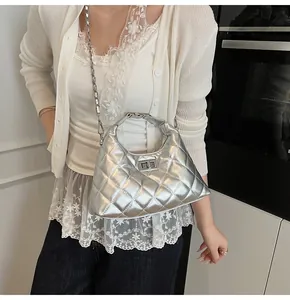 Détail du sac matelassé argenté avec bandoulière chaîne et fermoir tournant élégant