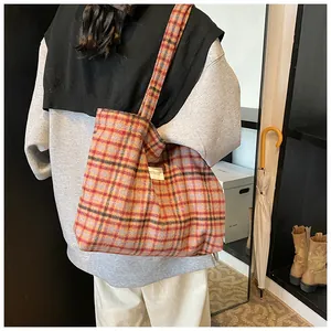 Detail view of large plaid tote bag showing fabric texture and woven brand label