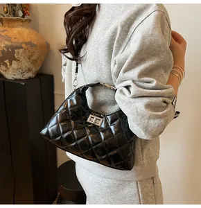 Détail d'un sac hobo en cuir matelassé noir avec fermoir rotatif argenté sur modèle