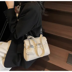 Cream litchi grain handbag with heart pendant shown on model in black blazer