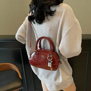 Sac Boston rétro bordeaux en cuir verni avec fermoir argenté et bandoulière réglable