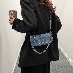 Sac bandoulière en jean bleu avec strass argentés et chaîne en métal sur mannequin