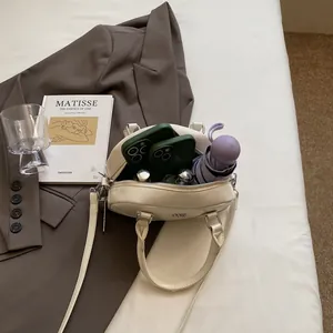 Sac Boston vintage crème à grande capacité montrant des accessoires à l'intérieur