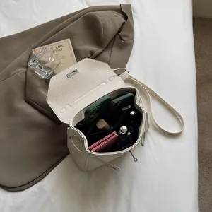 Chic beige litchi grain leather bucket bag with silver metal buckle and spacious interior