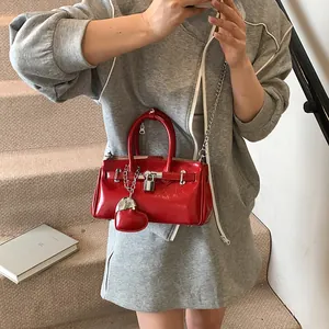 Fashionable red patent leather bucket bag with silver lock and heart charm detail