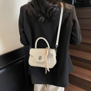 Off-white oil wax leather crossbody bag with chain and scarf detail on stairs