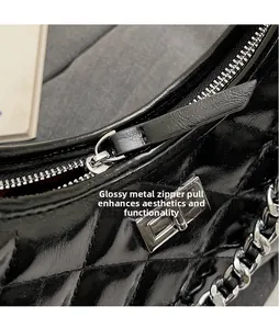 Macro shot of smooth silver hardware puller and black quilted leather on a bucket bag
