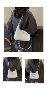 Close-up of white quilted bucket bag with silver turn-lock and chain strap detail