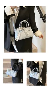 Close-up of light blue small square bag with polka dot scarf and adjustable strap