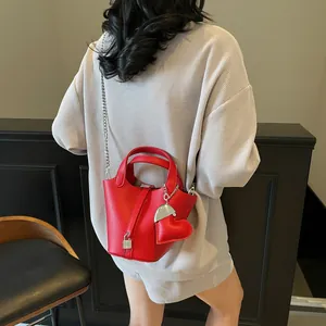 Elegant red litchi leather bucket bag with silver lock and heart charm detail