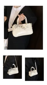 Detail of cream white leather mini Boston bag with polka dot scarf on handle