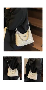 Macro detail of diamond quilted cream handbag with silver chain and metal clasp