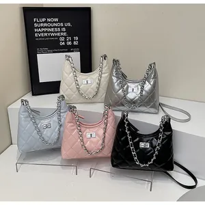 Close-up of five colorful quilted lattice crossbody bucket bags with silver chain straps