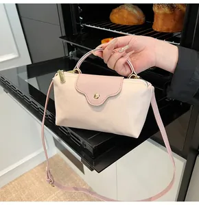 Detailed close-up of a nylon dumpling tote bag with leather flap and gold hardware