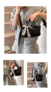 Detail of glossy black Boston bag featuring a stylish polka dot scarf on the handle