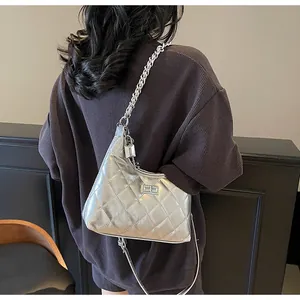 Close-up of silver quilted hobo bag with classic rectangular lock and chain strap