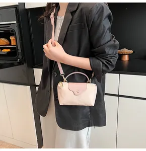 Detail of light pink nylon mini tote with leather handles and gold metal hardware finish