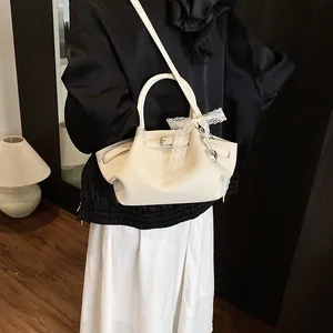 Elegant cream lychee leather underarm bag with lace ribbon and silver hardware details
