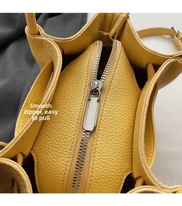 Macro detail of the smooth silver metal zipper and yellow lychee grain leather texture