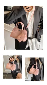 Vue détaillée d'un sac à main en cuir verni rose avec breloque triangle et fermoir en métal