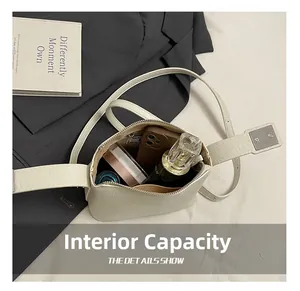 Internal capacity of off-white leather crossbody bag holding essentials like a smartphone