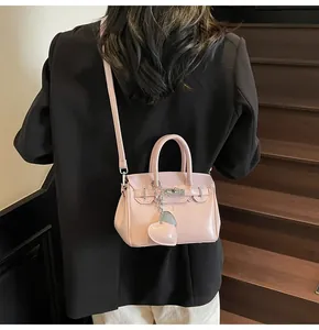 Pink PU leather Kelly bag with silver twist lock and heart pendant on a shoulder strap