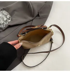 Detail of canvas crossbody bag interior with zip closure and magnetic snap buckle