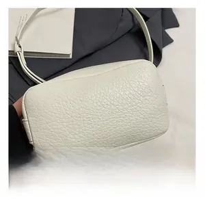 Detail showing the white lychee grain leather texture and adjustable silver metal buckle strap