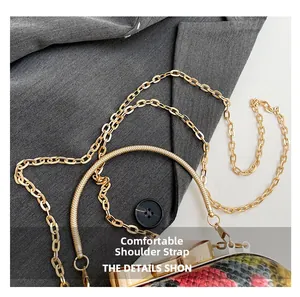 Detail of dual gold chain straps on a luxury snakeskin pattern handbag over a suit