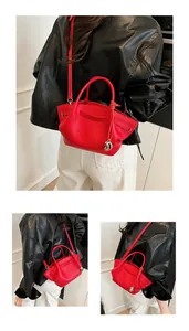 Detailed macro of red litchi texture tote bag with silver sphere pendant and strap