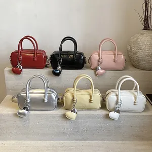 Mini glossy bowling bag in six colors featuring heart charm and top handle strap