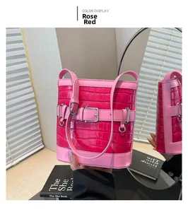 Detail of rose red crocodile embossed bucket bag with silver metal buckle ornament