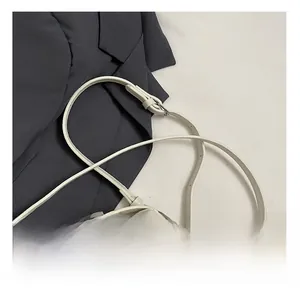 Detail showing adjustable leather strap with silver buckle on white pebble leather bag