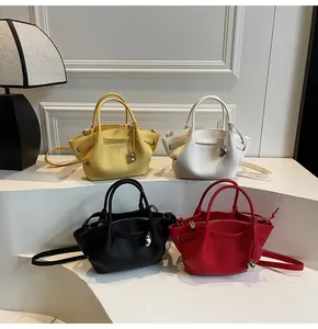 Detail of four colorful pleated bucket bags with silver heart charms and dual handles