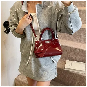 Vue détaillée du sac à main en cuir verni bordeaux avec fermoir argenté et pochette