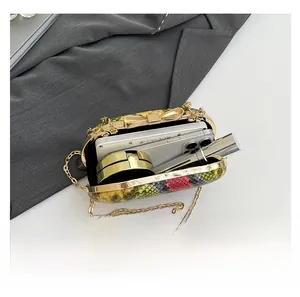 Interior view of snakeskin pattern clutch bag showing phone, lipstick, and makeup fit