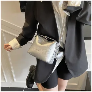 Detail of silver crossbody bag with lychee texture leather and heart-shaped charm