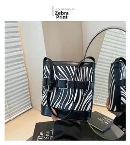 Detail of zebra pattern bucket bag with black leather belt buckle and mirror reflection