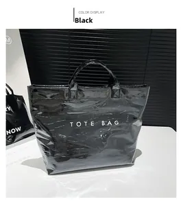 Detail of glossy black faux crocodile leather tote bag with white TOTE BAG printing