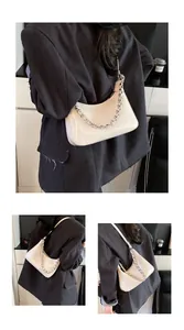 Detail view of crescent shoulder bag featuring silver metal chain and glossy leather finish