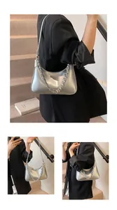 Detail of silver metallic crossbody bag featuring glossy finish and chunky chain strap
