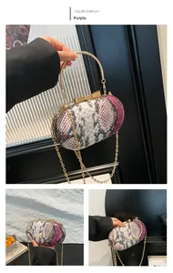 Detail of purple snake skin pattern evening bag with gold bow clasp and metal handle