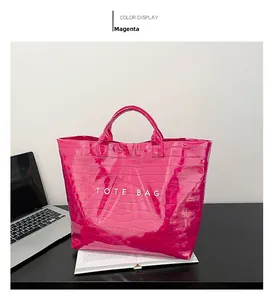 Detail of rose red tote bag with crocodile embossed texture and white text logo